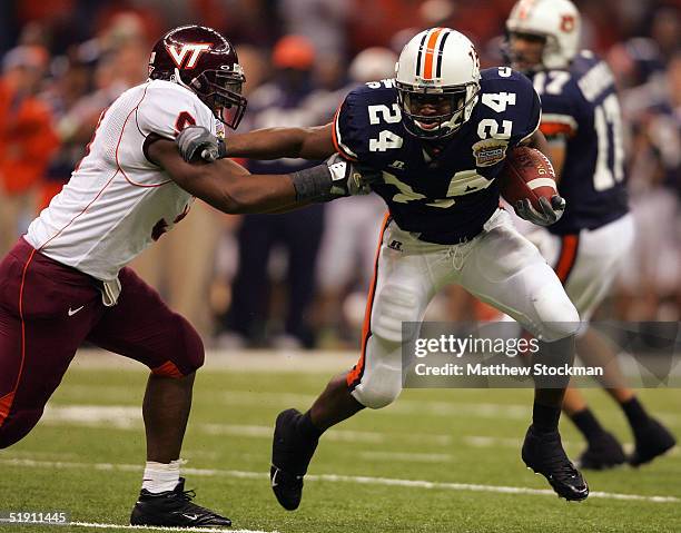 Running back Carnell Williams of the Auburn Tigers stiff arms Vince Hall of the Virginia Tech Hokies during the Nokia Sugar Bowl on January 3, 2005...