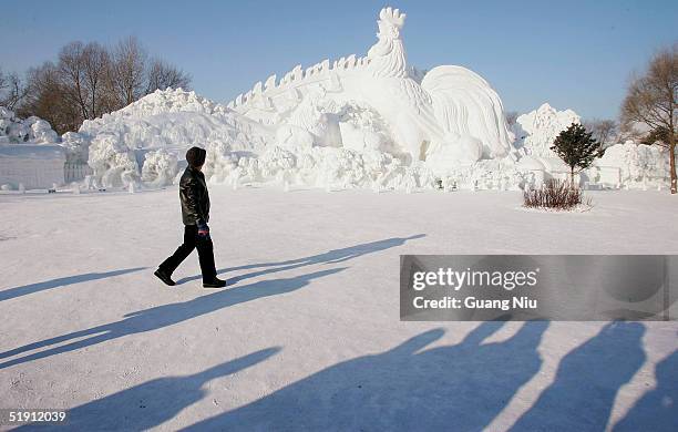 Labourer walks past an ice sculpture at the Ice and Snow Festival on January 4, 2005 in Harbin, China. The event, which is the first regional...