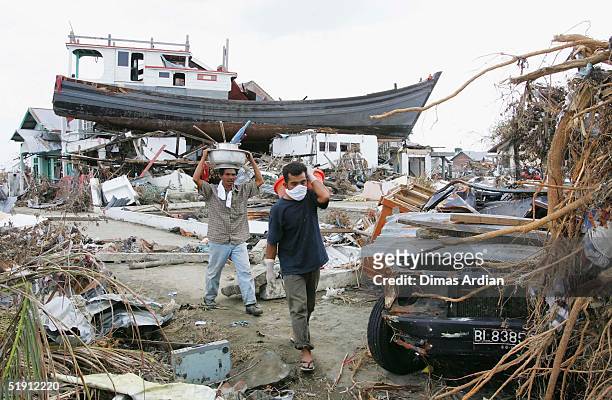 People displaced by the tsunamis, walk amid their ruined neighbourhood on January 4, 2005 in Banda Aceh, Indonesia. Indonesia, the country hardest...
