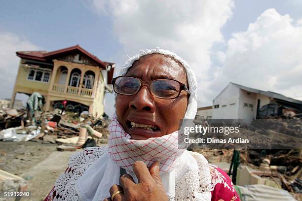 Asma, 50 years old cries as she stands next to her home that was destroyed by the Indian Ocean tsunami disaster, January 4, 2005 in Banda Aceh,...