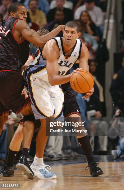 Shane Battier of the Memphis Grizzlies is defended by Andre Iguodala of the Philadelphia 76ers during the game at FedExForum on December 3, 2004 in...