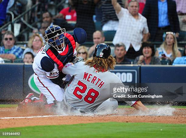 Jayson Werth of the Washington Nationals slides into home to score a ninth inning run against A. J. Pierzynski of the Atlanta Braves at Turner Field...