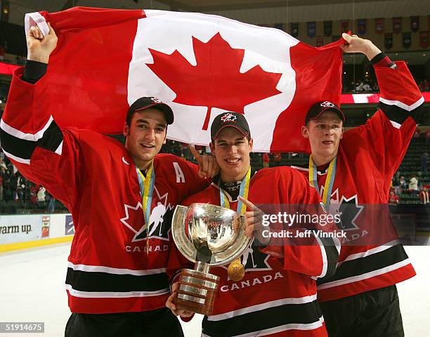 Corey Perry, Sidney Crosby and Patrice Begeron hold the World Junior Championship trophy after Canada won the gold medal game 6-1 over Russia at the...