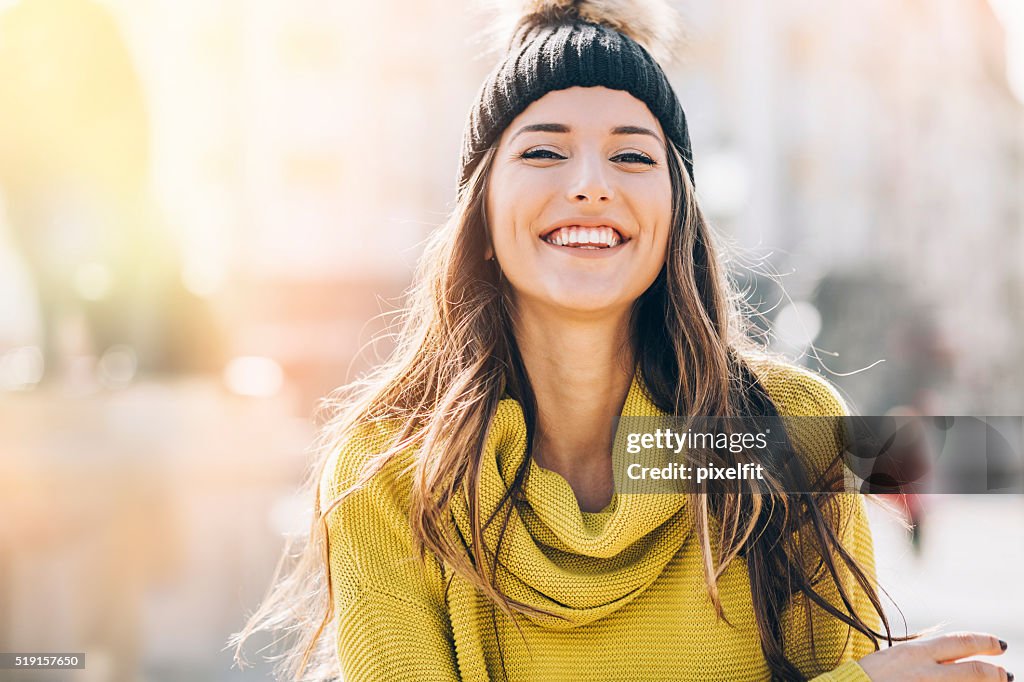 Souriante jeune femme dans la lumière du soleil