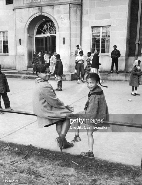 Sisters Linda and Terry Lynn Brown sit on a fence outside of their school, the racially segregated Monroe Elementary School, Topeka, Kansas, March...