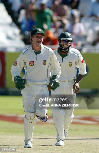 South African wicket-keeper AB de Villiers and fielder Hassim Amla celebrate taking the wicket of England's Robert Keys for 41 at Newlands Stadium in...