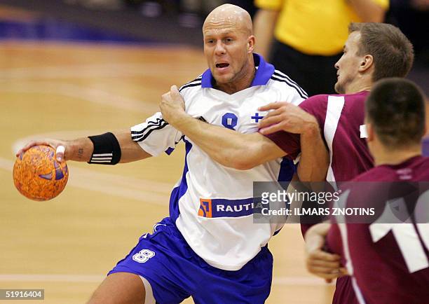 Johnny Hiltunen of Finland vies with Evars Klesniks of Latvia during their Euro 2006 qualification match in Cesis 05 January 2005. AFP PHOTO/ILMARS...