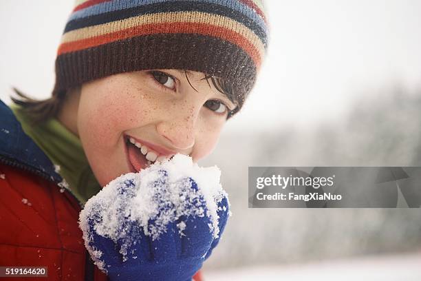 junge essen schnee - powder throw stock-fotos und bilder