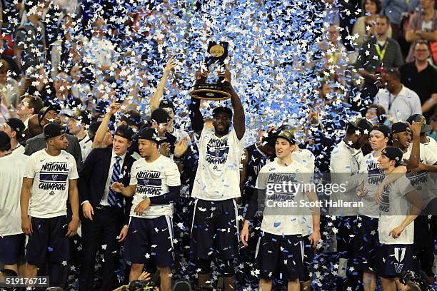 Daniel Ochefu of the Villanova Wildcats hoists the trophy after the Villanova Wildcats defeat the North Carolina Tar Heels 77-74 to win the 2016 NCAA...