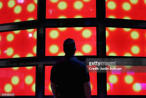 Man looks at a wall of Panasonic high definition televisions on display at the 2005 Consumer Electronics Show January 5, 2005 in Las Vegas, Nevada....