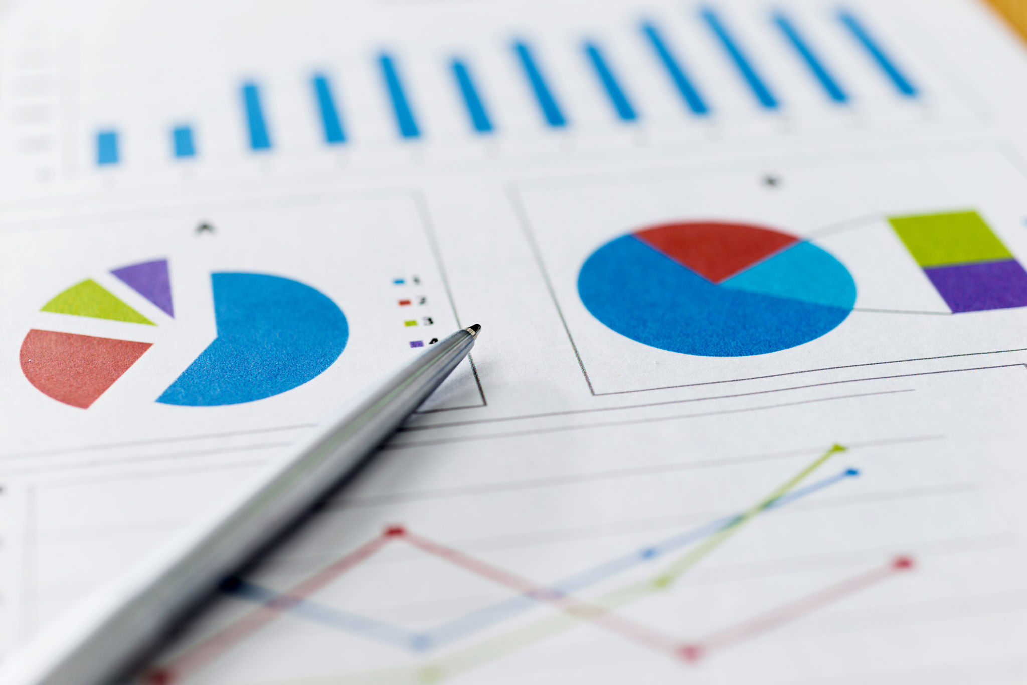 Pen on financial graphs and charts Pen on financial graphs and charts