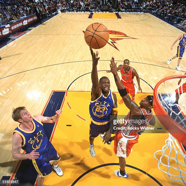 Jason Richardson of the Golden State Warriors lays up a shot over Larry Hughes of the Washington Wizards during a game at The Arena in Oakland on...