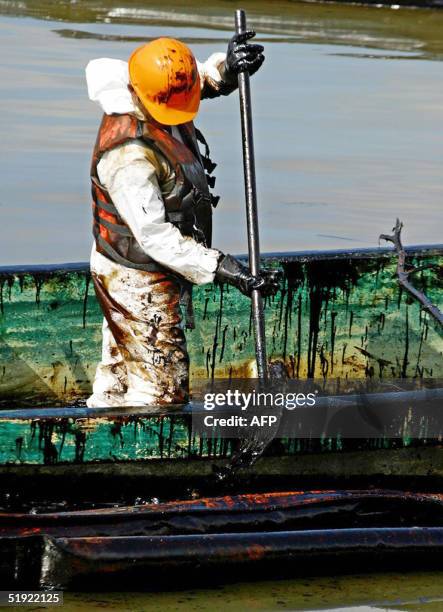 Workers of the state-owned Pemex oil company tries to remove oil from the Coatzacoalcos river, in the eastern coast state of Veracruz, 06 January...