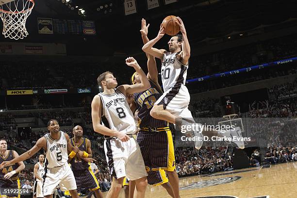 Emanuel Ginobili of the San Antonio Spurs shoots over teammate Rasho Nesterovic and David Harrison of the Indiana Pacers at the SBC Center January 6,...