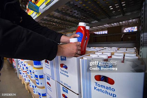 Customer holds bottles of Metro AG's own brand Aro tomato sauce inside a Metro Cash & Carry wholesale store in Duesseldorf, Germany, on Tuesday,...