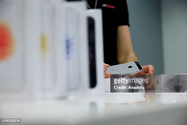 An employee puts an Apple phone in the box at a shop after Apple launched iPhone SE in Moscow, Russia on April 5, 2016.