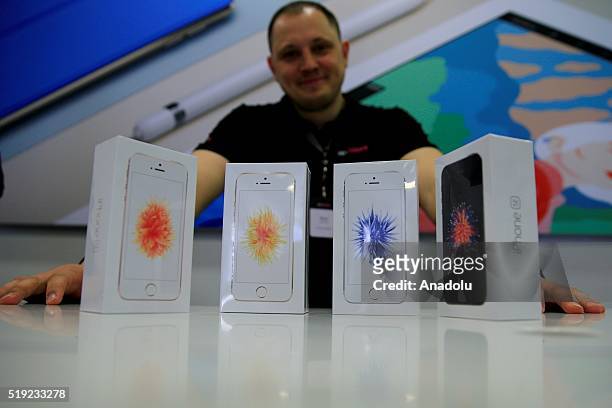An employee stands behind Apple phone at a shop after Apple launched iPhone SE in Moscow, Russia on April 5, 2016.
