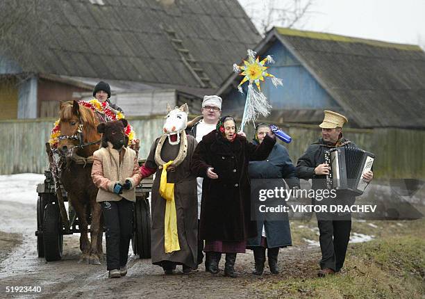 Masked local people with a horse carriage sing Christmas carols on a street of the town of Lepel, some 180 km from the capital Minsk, 07 January...