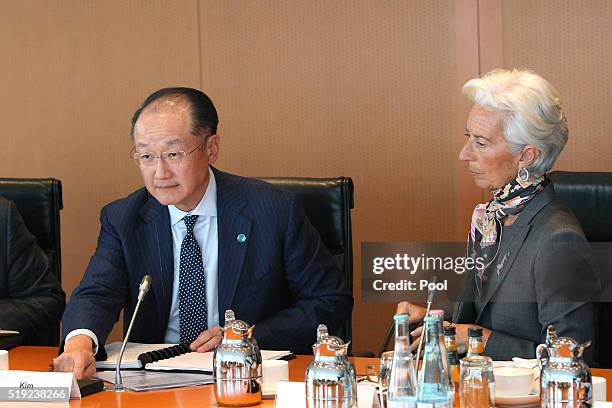 President Christine Lagarde sits next to president of the world bank Jim Yong Kim during talks with international finance organisations in the German...