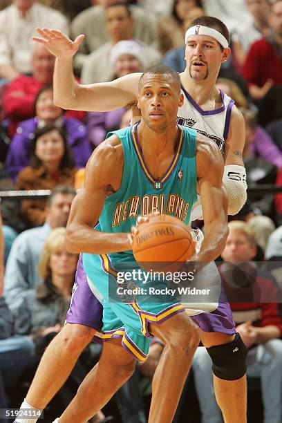 Brown of the New Orleans Hornets is defended by Brad Miller of the Sacramento Kings during the game on December 19, 2004 at Arco Arena in Sacramento,...