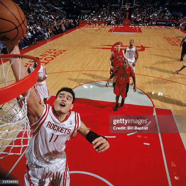 Yao Ming of the Houston Rockets takes the ball to the basket during a game against the Toronto Raptors at Toyota Center on December 20, 2004 in...