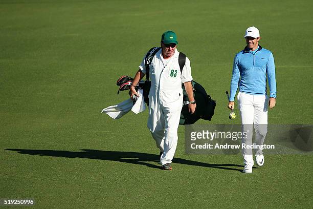 Rory McIlroy of Northern Ireland walks with Michael "Mick" Donaghy, caddie for Jamie Donaldson of Wales during a practice round prior to the start of...
