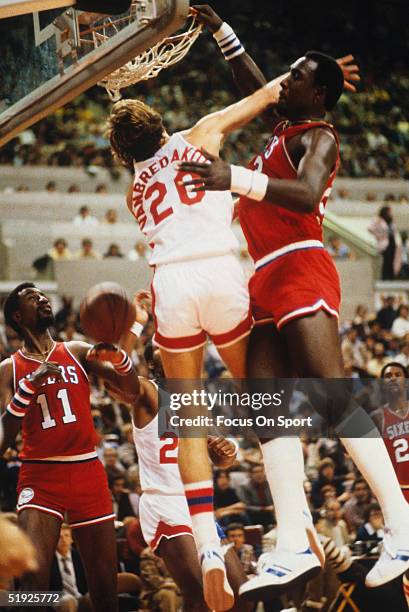 Philadelphia 76ers' center Darryl Dawkins jumps to dunk against New York Nets' Jan Van Breda Koff.