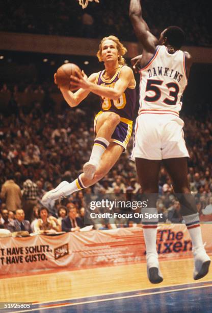 Los Angeles Lakers' guard Brad Davis jumps for a shot against Philadelphia 76ers' Darryl Dawkins.