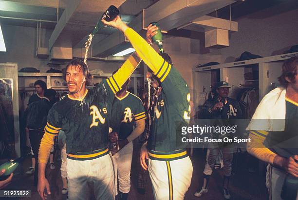 Oakland Athletics' Ken Holtzman and Rollie Fingers celebrate in the clubhouse after defeating the Baltimore Orioles to win the American League...