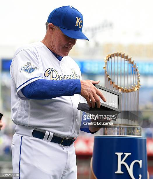 Ned Yost manager of the Kansas City Royals looks at his World Series Championship ring during a ceremony prior to a game against the New York Mets at...