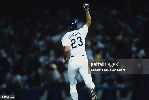 Los Angeles Dodgers' Kirk Gibson gestures to the crowd after hitting a home run during the World Series against the Oakland Athletics at Dodger...
