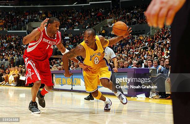 Kobe Bryant of the Los Angeles Lakers drives to the hoop against Tracy McGrady of the Houston Rockets on January 7, 2004 at the Staples Center in Los...