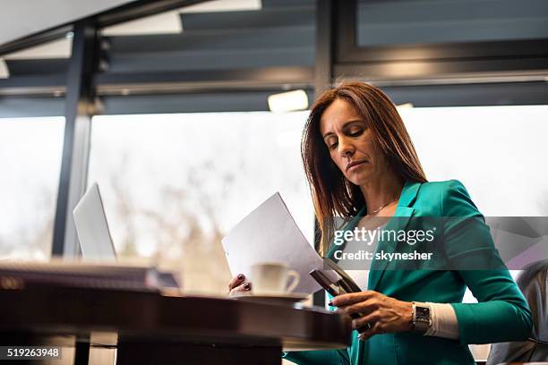 serious businesswoman stapling documents in the office. - staples office stockfoto's en -beelden