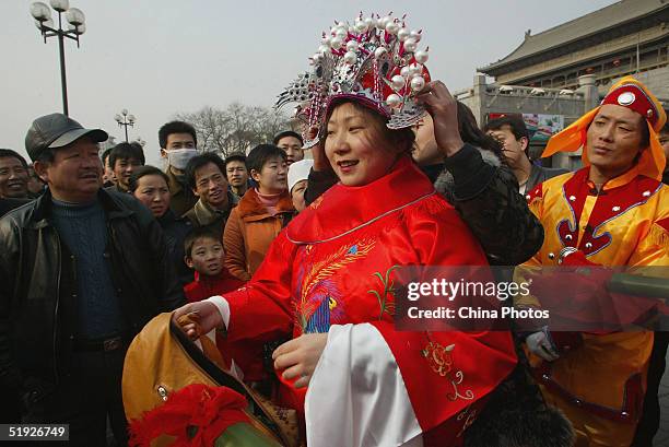 Chinese woman dresses as a bride during a rehearsal of a Chinese traditional wedding on January 8, 2005 in Xian, China. Some young Chinese are going...