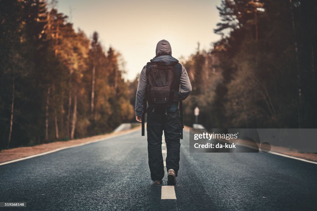 Traveler with backpack walking forward