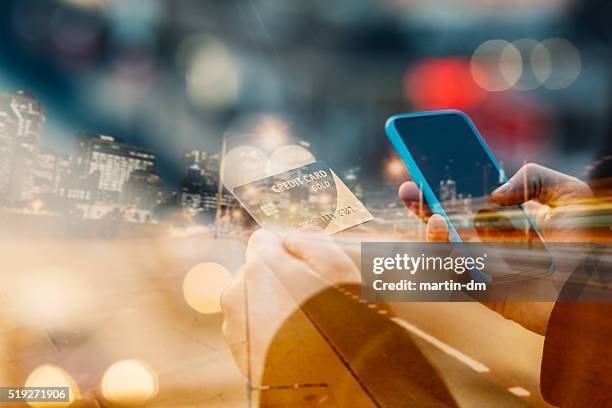 man holding credit card and texting - shopping abstract stockfoto's en -beelden