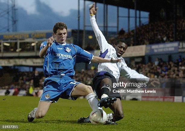 Shaun Wright-Phillips of Manchester is tackled by Alex Bruce of Oldham during the FA Cup third round match between Oldham Athletic and Manchester...