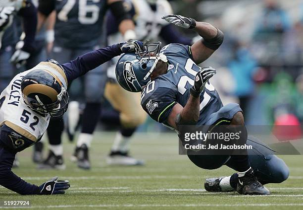 Linebacker Tommy Polley of the St. Louis Rams grabs the face mask of running back Maurice Morris of the Seattle Seahawks which in the end nullified...