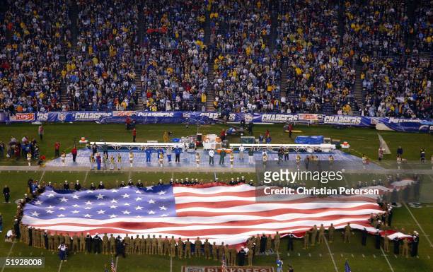 The U.S. Flag in the shape of the country is displayed on the field during the National Anthem before the AFC wild-card playoff game between the San...