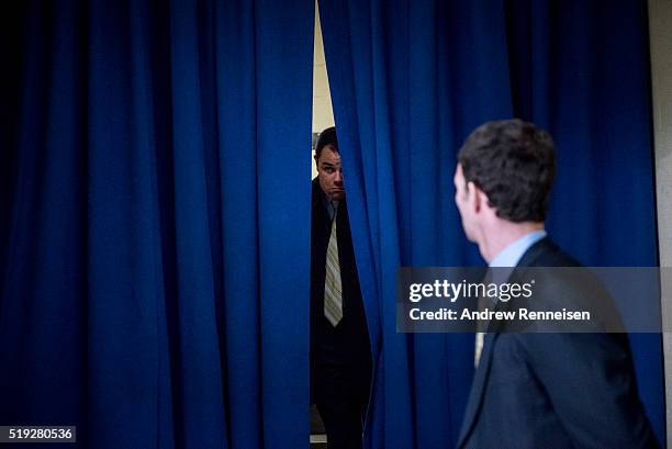 Secret service agent peers through a curtain prior to the arrival of Democratic presidential candidate Hillary Clinton at a Women for Hillary Town...