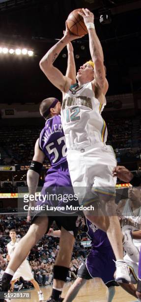 Chris Andersen of the New Orleans Hornets makes a layup around Brad Miller of the Sacramento Kings at the New Orleans Arena on January 8, 2005 in New...