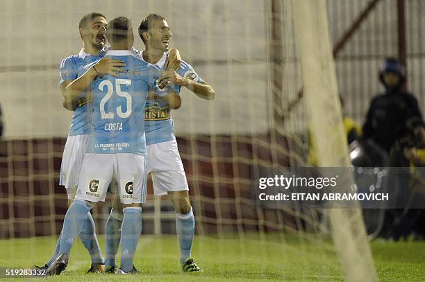 Perus Sporting Cristal player midfielder Horacio Calcaterra celebrates with teammates forward Santiago Silva and midfielder Gabriel Costa upon...