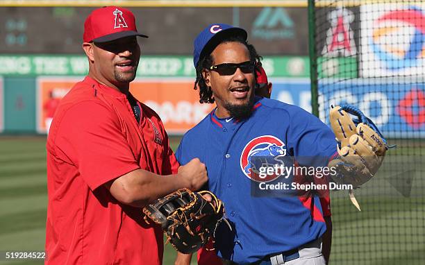 Hitting consultant Manny Ramirez of the Chicago Cubs is greeted by first baseman Albert Pujols of the Los Angeles Angels of Anaheim before the game...