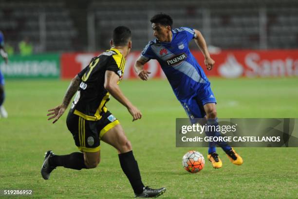 Venezuelan Tachira's Sergio Herrera Month vies for the ball with Ecuadorean Emelec's Angel Mena during a Libertadores Cup football match in San...