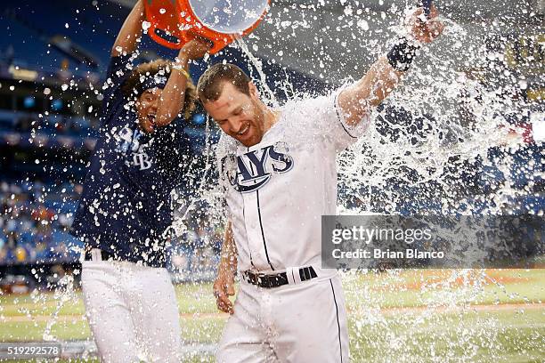 Second baseman Logan Forsythe of the Tampa Bay Rays is doused with ice and water from the cooler by pitcher Chris Archer following the Rays' 3-2 win...