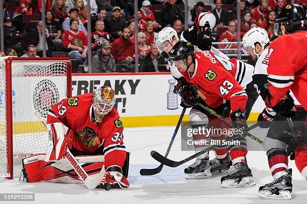 Connor Murphy and Brad Richardson of the Arizona Coyotes swing at the puck against Viktor Svedberg of the Chicago Blackhawks in front of goalie Scott...