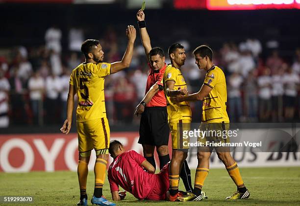 Referee Ulises Mereles gives the yellow card to Hector Perez of Trujillanos during a match between Sao Paulo v Trujillanos as part of Group 1 of Copa...