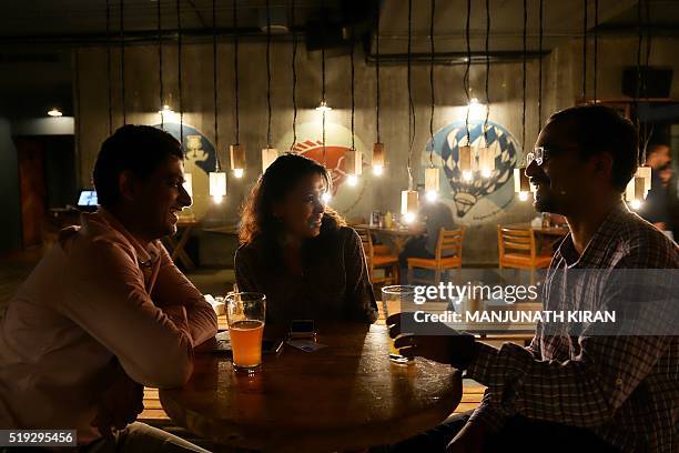 In this photograph taken on March 30 customers share a conversation over beer at The Arbour Microbrewery in Bangalore. India's version of craft...