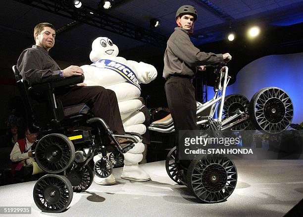 Bibendum , the mascot for the French Michelin tire company, poses with two men demonstrating devices equiped with the Michelin "Tweel" 09 January...