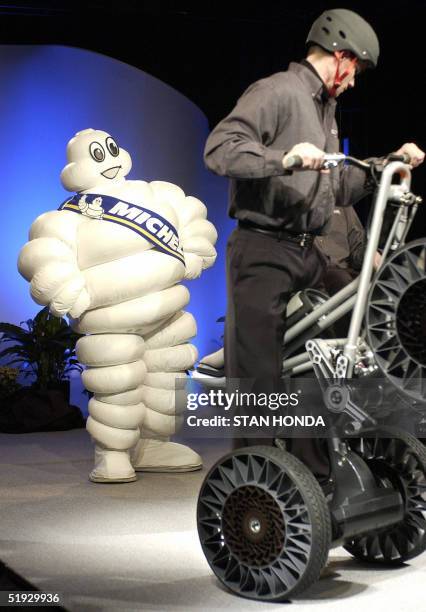 Bibendum , the mascot for the French Michelin tire company, watches a man demonstrating a devices equiped with the Michelin "Tweel" 09 January 2005...